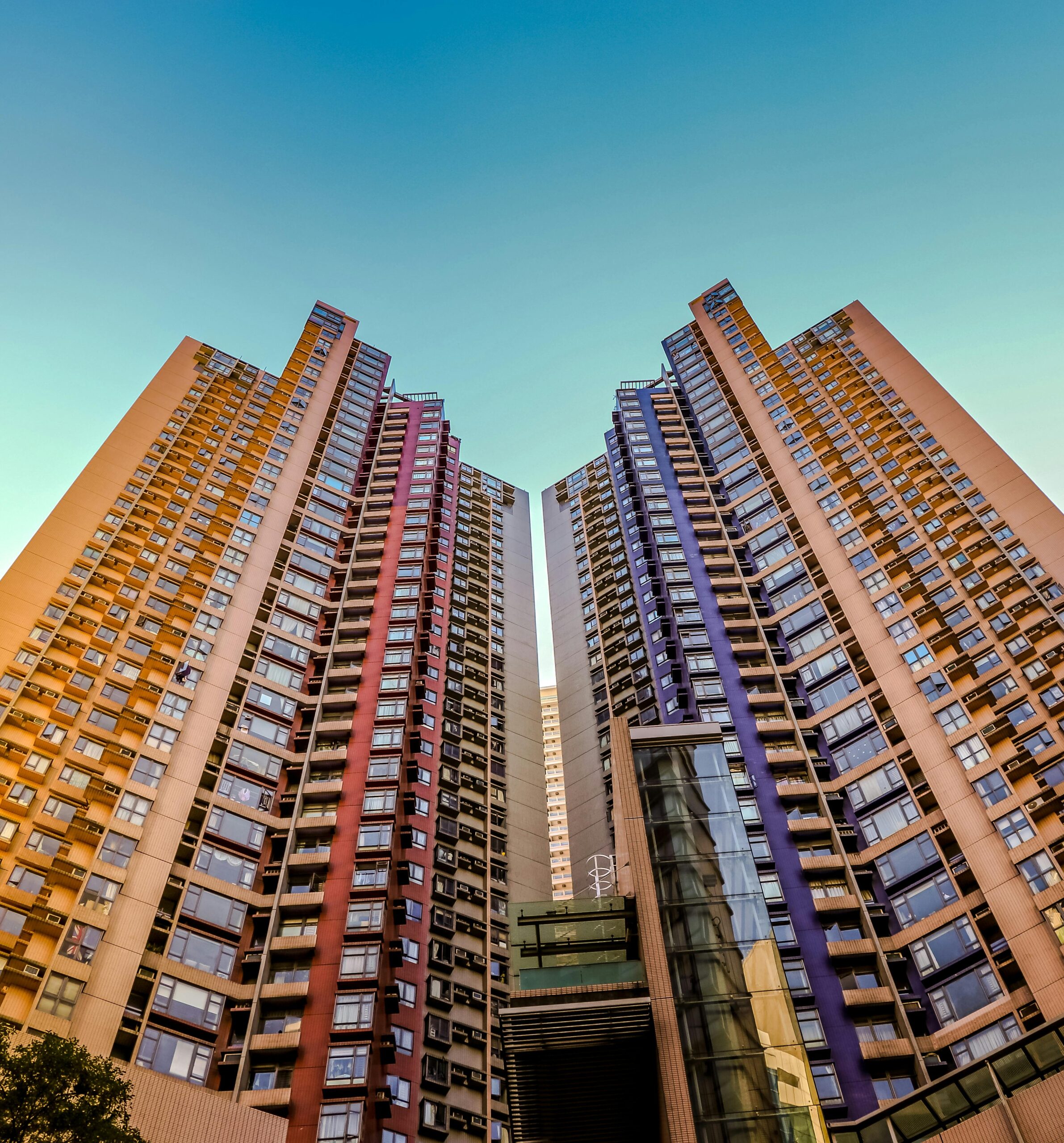 Home Tall, colorful skyscrapers reaching into the blue sky in Hong Kong, showcasing modern architecture.